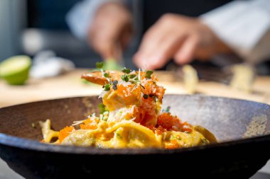 Spaghetti Carbonara Makarnalı Yumurta ve Peynirli Krem Krem Soslu Karides ve mikro otlu Stüdyo ışığı altında Dünya Çemberi kâsesinin tepesinde.