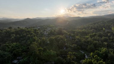 Aerial view of terraced agriculture field among greenery mountains with the blue cloudy and sunlight in the northern of Thailand, Omkoi district, Chiang Mai. clipart