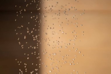 Soyut arka grond su durdurma hareketini düşürdü ve açık havada bulanık turuncu kahverengi arka planda duştan yere damladı.