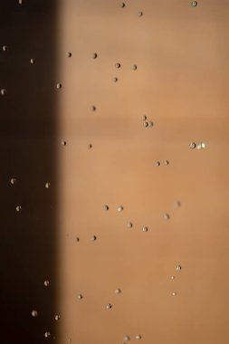 Soyut arka grond su durdurma hareketini düşürdü ve açık havada bulanık turuncu kahverengi arka planda duştan yere damladı.