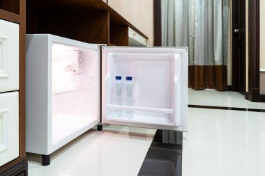 Buzdolabı. Delux Otel 'de masanın altında yanında ahşap bir masa var..