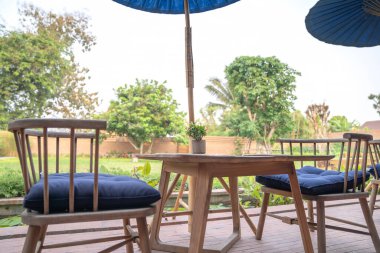 Tayland Kuzey geleneksel ahşap masa ve sandalye seti üzerinde hasır plaka ile arka planda bulanık