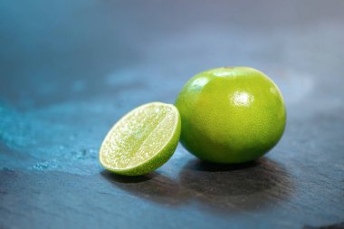 Taze limonu kapat, stüdyo ışığı altındaki lemone mutfakta siyah taş tabakta..