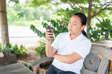 Kişi oyun oynuyor ve ekrandaki telefona dokunuyor. Telefon modern bir iletişim teknolojisidir. Kişinin portresi oturuyor, bakıyor ve cep telefonlarına dokunuyor.