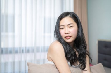 Asyalı kadın yatak odasında seksi omzuyla poz veriyor..