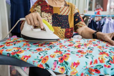 Öğrenci eteği ve kıyafetlerini bir evde ütüleyen yaşlılar..