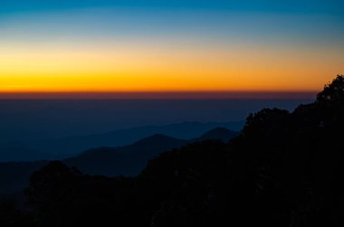 The beautiful sunrise at Doi intanon national park, Chiang Mai in the morning.Sun is rising from the hill to shy with beautiful yellow orange light. clipart