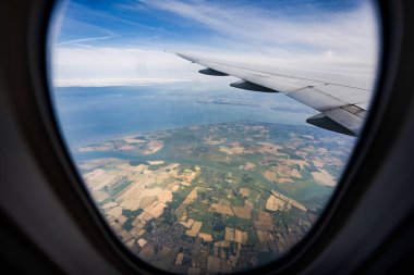 the serene beauty from an airplane window, featuring the wing silhouetted against an expansive, cloud-filled sky, instilling a sense of height and peacefulness. clipart