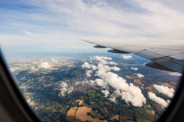 the serene beauty from an airplane window, featuring the wing silhouetted against an expansive, cloud-filled sky, instilling a sense of height and peacefulness. clipart