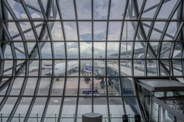 Bangkok, Thailand - 9 July 2023, Suvarnabhumi Airport Gate C2 offers a view through the window to a Thai Airways plane, ready for its flight from BKK to London. clipart