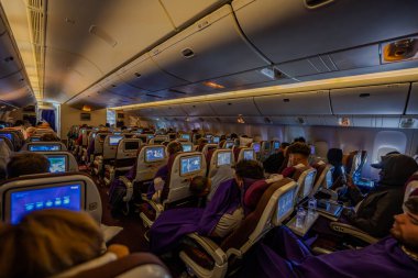 Bangkok, Thailand - 9 July 2023, Inside a Thai Airways plane, A calm and relaxed atmosphere, with every seat occupied, fostering a soothing and sleepy in flight environment clipart