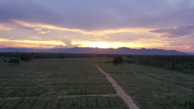 Güneşten gelen altın ışıkta dağın arkasındaki drone 'dan duyusal an görüntüsü.