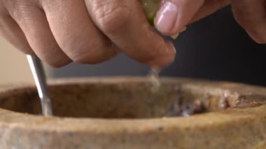 Şefin güçlü parmakları taze limonu sıkıca kavrıyor. Lezzet suyunun her damlasını havana sıkıyor..