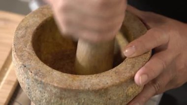 Şef ağır harç ve tokmağı alır, ham baharat ve otların karışımını ince bir öğütülmüş Tayland yeşil köri macununa dönüştürmeye hazırdır..