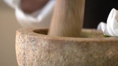 Şef ağır harç ve tokmağı alır, ham baharat ve otların karışımını ince bir öğütülmüş Tayland yeşil köri macununa dönüştürmeye hazırdır..