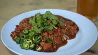 Pilav üzerine tavuk sosu, yumuşak tavuk parçalarını, yumuşak beyaz pirinç yatağının üzerinde servis edilen lezzetli ve lezzetli bir sosla birleştiren lezzetli bir yemektir.