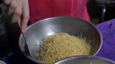 Tayland 'daki yerel şehriye lokantasında büyük bir tencerede kaynamış sarı erişte..