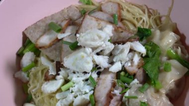 Asya sarısı Erişte, domuz eti ve yengeç eti, hamur tatlısı ve sebzeler pembe kasede..