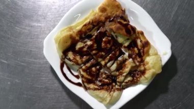 Çikolata tatlandırılmış yoğunlaştırılmış sütle kaplı Roti, restorandaki müşterilere servis yapmaya hazır..