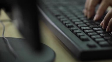 Bir ofis kadınının eli Tayland İngilizcesi klavyesi ile sağlanan siyah bir bilgisayar klavyesinde yazı yazıyor..