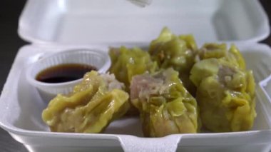Yanında sos olan beyaz köpük bir kutuda altı kıymalı domuz etli börek üzerine kızarmış sarımsak serpin ve ondan sonra yemeye hazır olun..