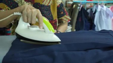Öğrenci eteği ve kıyafetlerini bir evde ütüleyen yaşlılar..