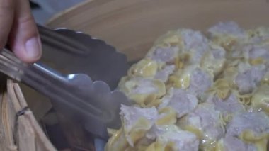 Yanında sos olan beyaz köpük bir kutuda altı kıymalı domuz etli börek üzerine kızarmış sarımsak serpin ve ondan sonra yemeye hazır olun..