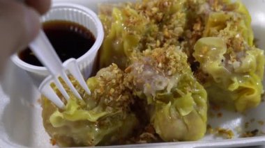 Yanında sos olan beyaz köpük bir kutuda altı kıymalı domuz etli börek üzerine kızarmış sarımsak serpin ve ondan sonra yemeye hazır olun..