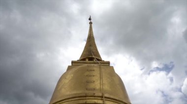 Bangkok, Tayland 'ın başkenti Bangkok' ta, bulutlu bir çatıda, Altın Dağda Budist Wat Saket 'in altın rengi şapşalı. Altın dağ önemli bir Budist mekanıdır ve Wat Saket 'in ünlü sembolüdür..