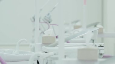 Diş sağlığı kliniğinin bulanık arka planında modern beyaz bir diş lambası ve yansıtıcı ekipmanın yan görüntüsü..