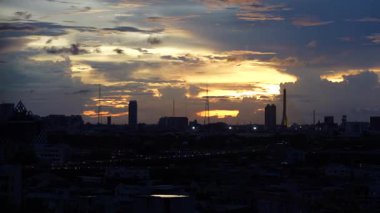 Alacakaranlık Bangkok 'ta 15 kattan alacakaranlığa dönerken Phahonyothin Soi 3, zaman dilimi şehir manzarasından gece enerjisine geçişi sembolize eden trafiğin canlı ışık çizgilerini yakalıyor..