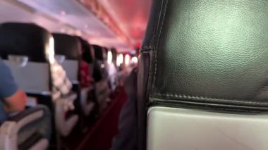 Bangkok, Tayland - 27 Kasım 2023, AirAsia uçağının içinde, uçak kalkışa hazırlanırken yürüyüş yolu, koltuklar ve yolcularla atmosferi yakalıyor..