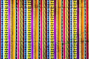 Sarı, pembe, mavi ve siyah çizgilerden oluşan çarpıcı bir duvar resmi enerjik ve yaratıcı bir hava katar..