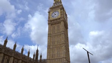 Londra 'daki ikonik Big Ben saat kulesinin yakın çekimi. Parlak mavi gökyüzüne karşı karmaşık mimari ayrıntıları gösteriyor..