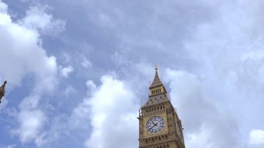 Londra 'daki ikonik Big Ben saat kulesinin yakın çekimi. Parlak mavi gökyüzüne karşı karmaşık mimari ayrıntıları gösteriyor..