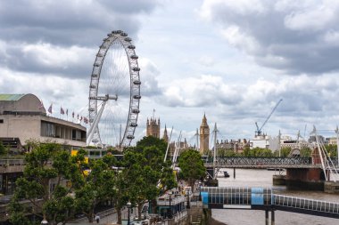 Londra manzarası Big Ben ve gözlem çarkını ön plana çıkarıyor, tarihi ve modern mimariyi nehir kıyısı boyunca harmanlıyor..
