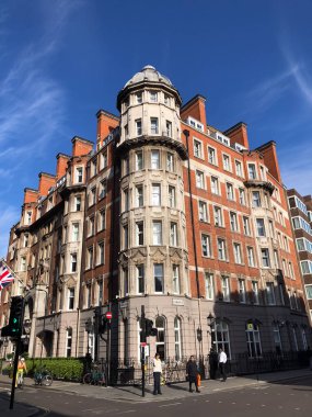 Londra, İngiltere - 10 Temmuz 2023, Londra 'da bir sokak köşesinde yedi katlı tuğla bina, çok sayıda penceresi var ve geleneksel İngiliz tarzında bir otel olarak tasarlandı..