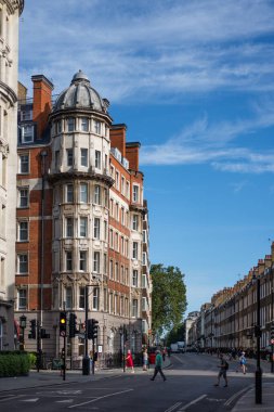 Londra, İngiltere - 10 Temmuz 2023, Londra 'da bir sokak köşesinde yedi katlı tuğla bina, çok sayıda penceresi var ve geleneksel İngiliz tarzında bir otel olarak tasarlandı..