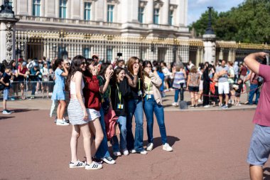 Londra, İngiltere - 10 Temmuz 2023, Buckingham Sarayı Parlak, güneşli bir günde Canlı Turistlerin Fotoğraf Çekmesi ve Muhafızların Değişmesini Bekleme Günü.