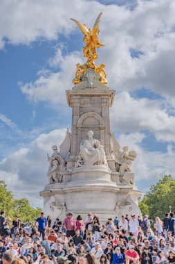 Londra, İngiltere - 10 Temmuz 2023, Victoria Anıtı 'nın Görkemli Manzarası Londons Iconic Simgeleriyle süslenmiş, Büyük bir Turist kalabalığı tarafından çevrelenmiş kısmen bulutlu bir gökyüzü altında.