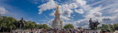 Londra, İngiltere - 10 Temmuz 2023, Victoria Anıtı 'nın Görkemli Manzarası Londons Iconic Simgeleriyle süslenmiş, Büyük bir Turist kalabalığı tarafından çevrelenmiş kısmen bulutlu bir gökyüzü altında.