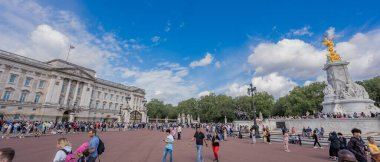 London, England - 10 July 2023, Buckingham Palace and Victoria Memorial Stand Proudly Under a Clear Sky, with Tourists Enjoying the Vibrant Scene. clipart