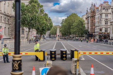 Londra, İngiltere - 10 Temmuz 2023, Westminster yakınlarındaki bir yol bariyerler ve polis varlığıyla tıkandı, muhtemelen siyasi ya da resmi bir olay için. İzleyiciler barikatların arkasında toplandı..
