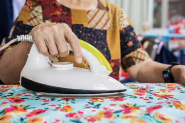 Öğrenci eteği ve kıyafetlerini bir evde ütüleyen yaşlılar..