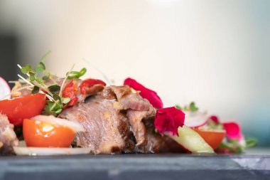 Üzerine tereyle süslenmiş Baharatlı Tayland bifteği salatası ve mikro bitkiler dikdörtgen taştan bir tabağa konuldu.. 