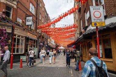 Londra, İngiltere, 11 Temmuz 2023, Çin Mahallesi 'ndeki Bustling Caddesi Kırmızı Fenerlerle süslenmiş Restoranlar ve Marketler Arasındaki Canlı Kültürel Sahne.