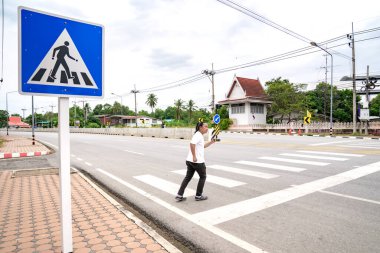 Asyalı bir adam yürümeye ve yaya geçidinden Tayland 'a koşmaya hazırlanıyor..