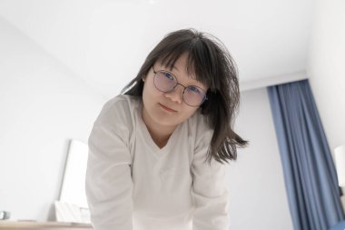 Seksi ve tatlı Japon, Çinli Taylandlı kadın beyaz uzun kollu tişört giyiyor, kameraya bakıyor..