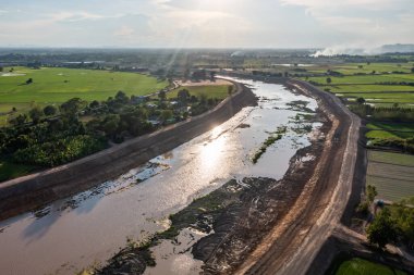 İnşaat, yağmur mevsiminde sel baskınını önlemek için bir kanal ve baraj kazıyor. Tarih 14 Mayıs 2021, Uthai Thani, Tayland.