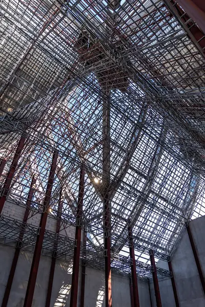 İnşaat alanında inşaat halindeki devasa çelik çatı iskeleti yapısının yükseliş açısı fotoğraf çekimi.